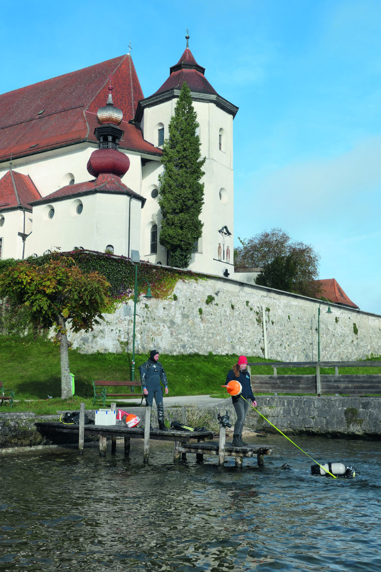 Die Forschungstaucher des Kuratoriums Pfahlbauten gehen vor dem Kloster von Traunkirchen ins flache Wasser.