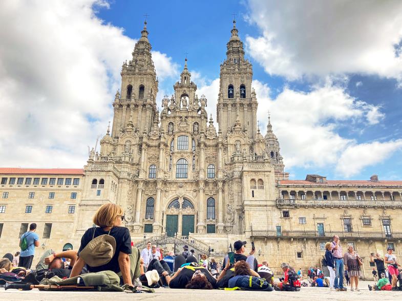 Am Ziel angekommen: Pilger sitzen vor der Kathedrale von Santiago de Compostela, am Ende des Jakobsweges. (Foto: Emilio Rappolt / picture alliance / dpa)