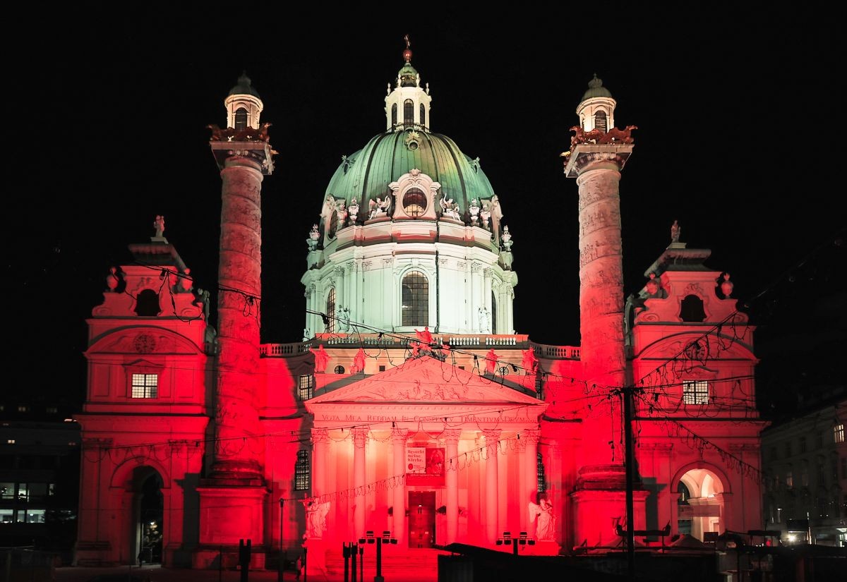 Die rot angestrahlte Wiener Karlskirche am "Red Wednesday" 2023