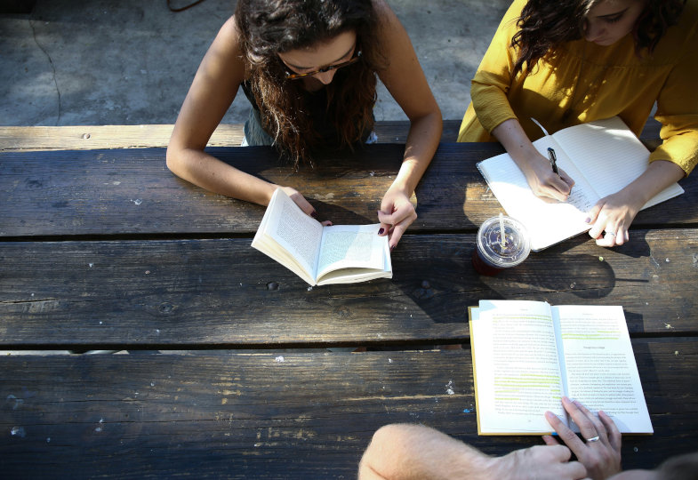 Menschen über Bücher gebeugt