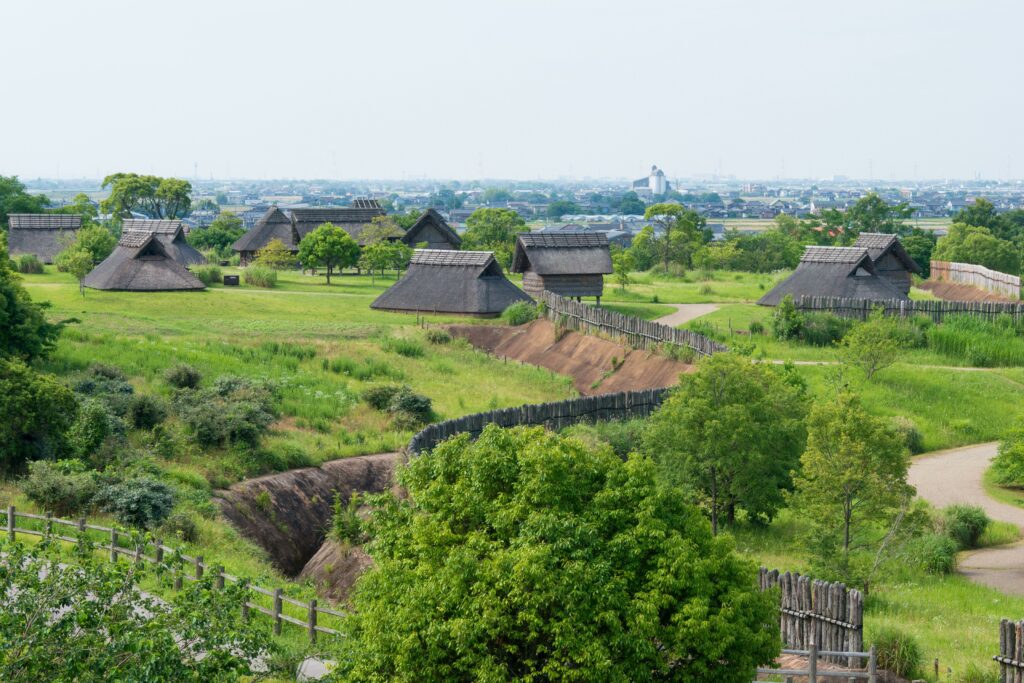 Die Stätte Yoshinogari aus der Yayoi-Zeit war mit einer für diese Zeit typischen Grabenanlage umgeben, die noch heute sichtbar ist. Zudem wurden einige der historischen Häuser wieder aufgebaut. Die Stätte war zudem mit einer hohen Pallisade aus Holz umgeben. Die Häuser stehen zum Einen auf Pfählen, zum anderen wurden sie direkt auf Fundamenten im Boden gebaut. Typisch für diese Häuser ist das Dach, das bis auf den Boden reicht.