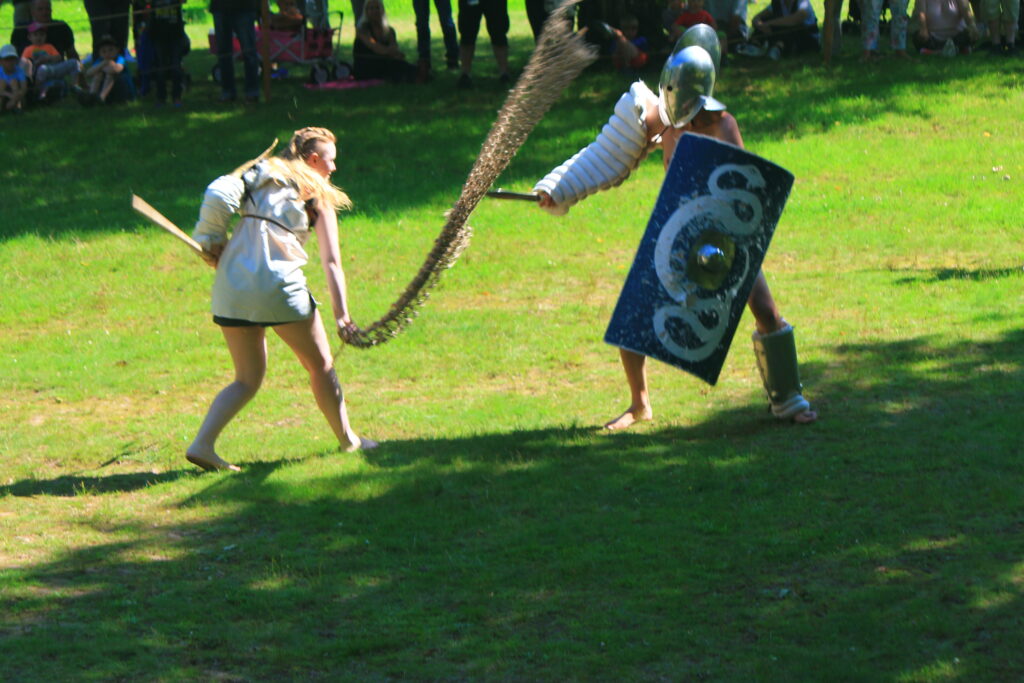 Kampf zwischen Retiara (links) und Secutor (rechts) auf der Saalburg 2017. Die Gattung des Retiarus erfreute sich in der Kaiserzeit großer Beliebtheit. Die zwei kleinen Gucklöcher im Helm des Secutor schränken seine Sicht zwar stark ein, schützen jedoch sein Gesicht vor dem Dreizack des Retiarus.