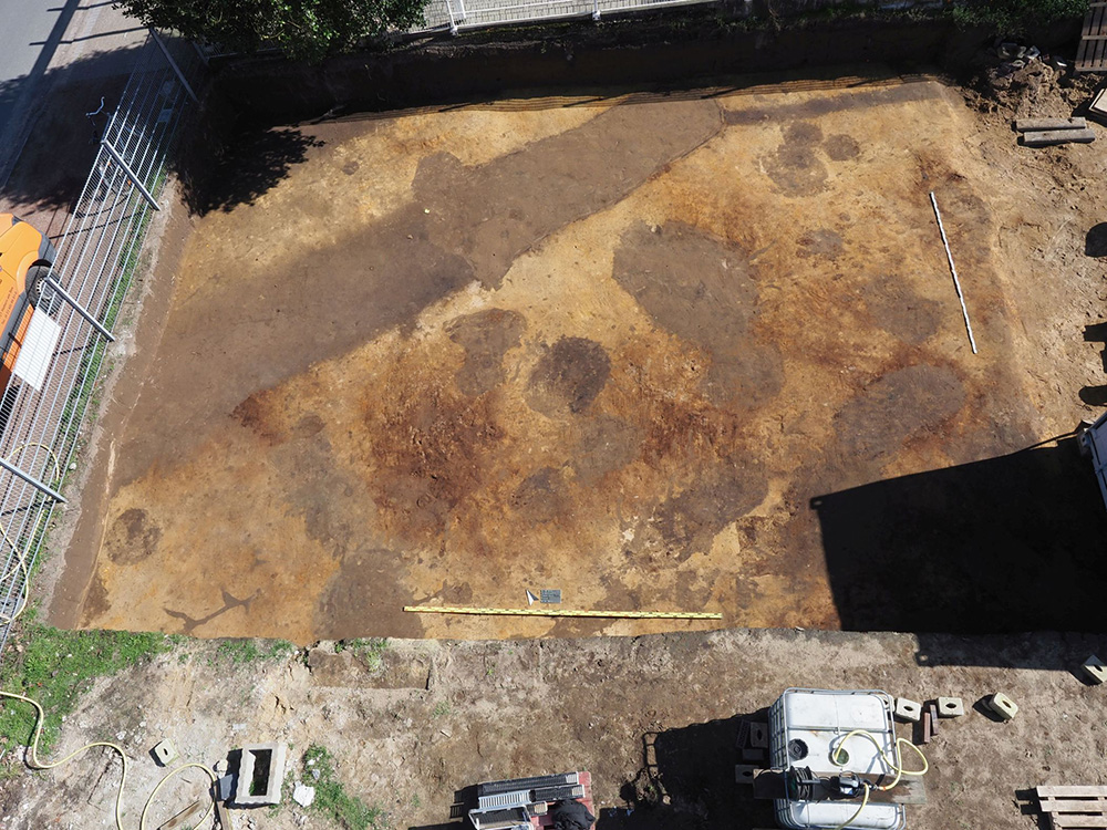 Die römischen Fundamentspuren in Haltern am See zeichnen sich markant im gelben Sand ab. Der verfüllte Wehrgraben setzt sich als breite Spur unter der Straße "Am Uferkastell" fort. 